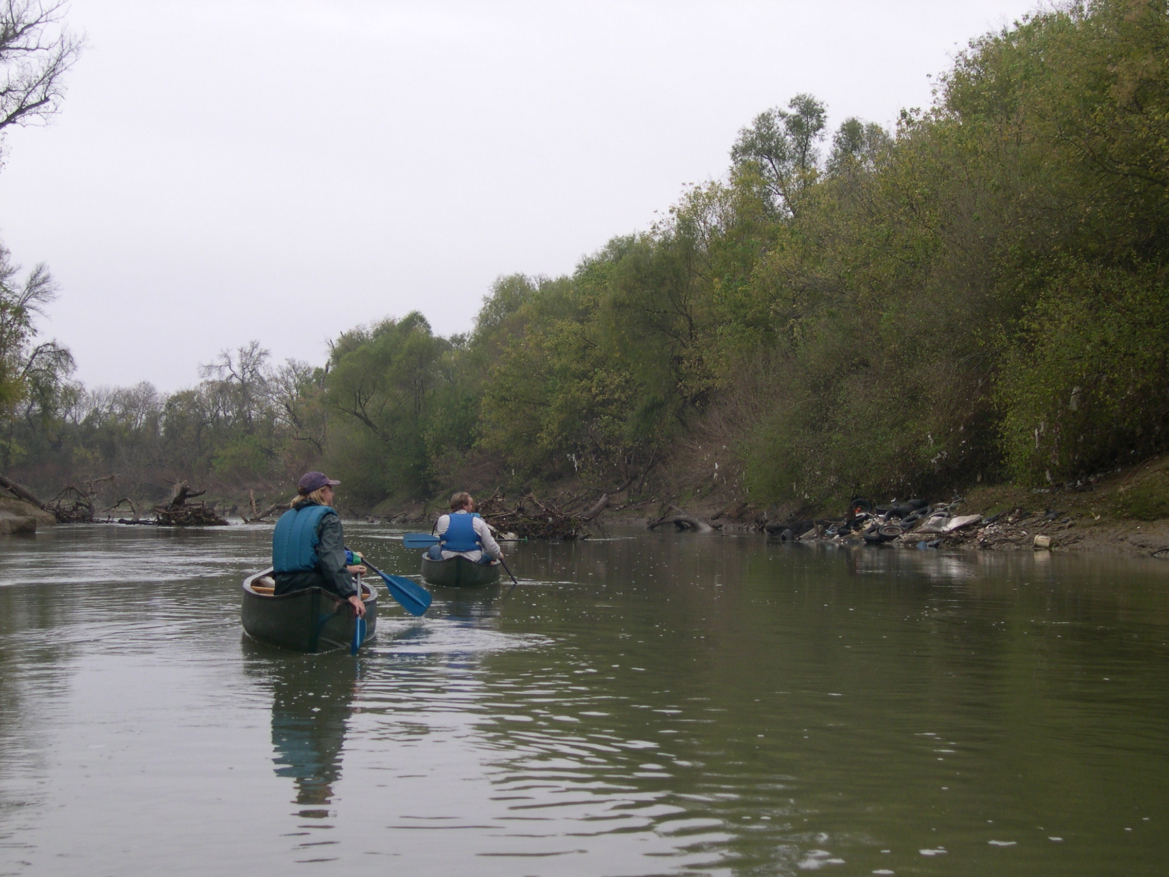 Candid photo of Chris Morris paddling down the Trinity River with a group of students.